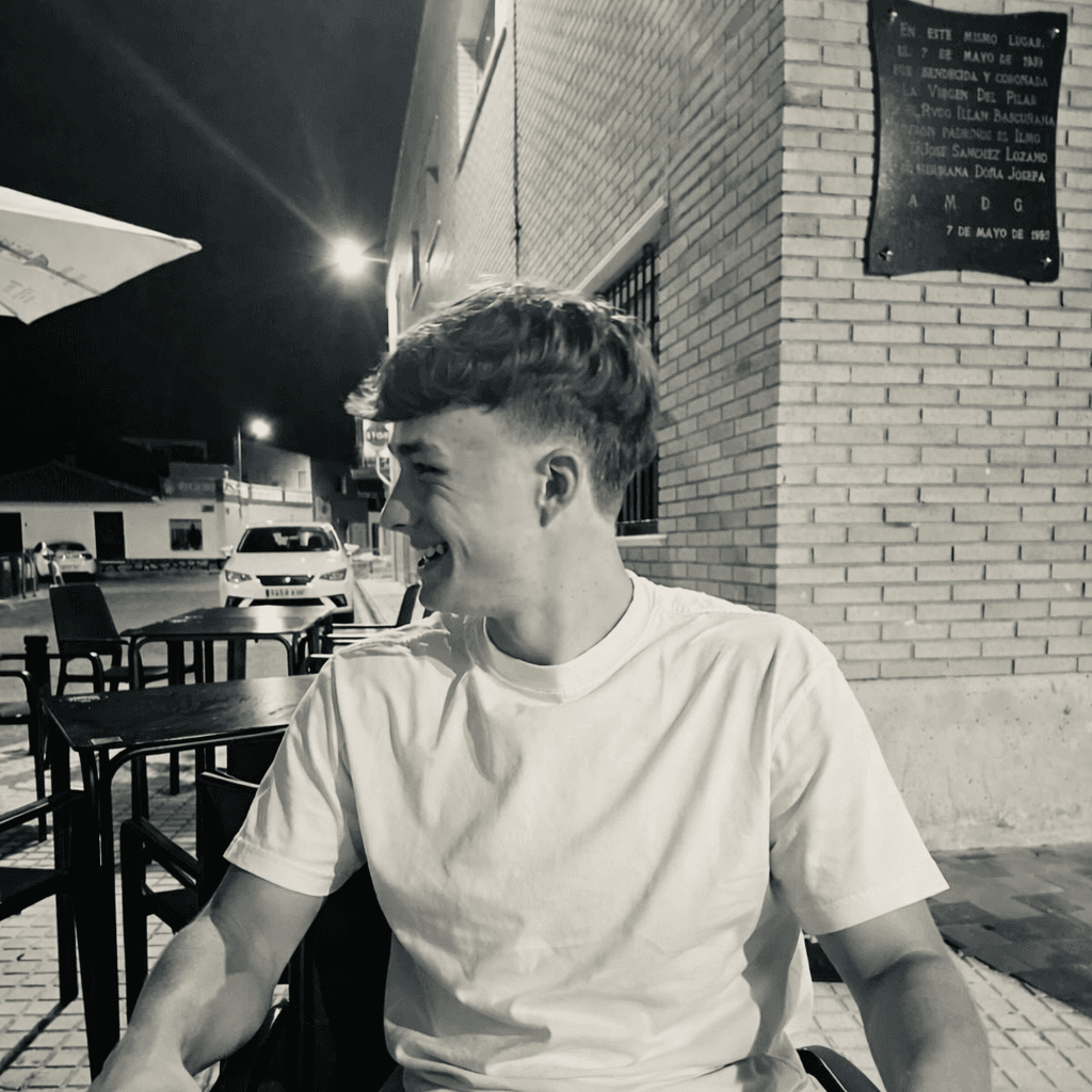 Bavo De Bondt laughing, sitting outside at a café terrace in the evening
